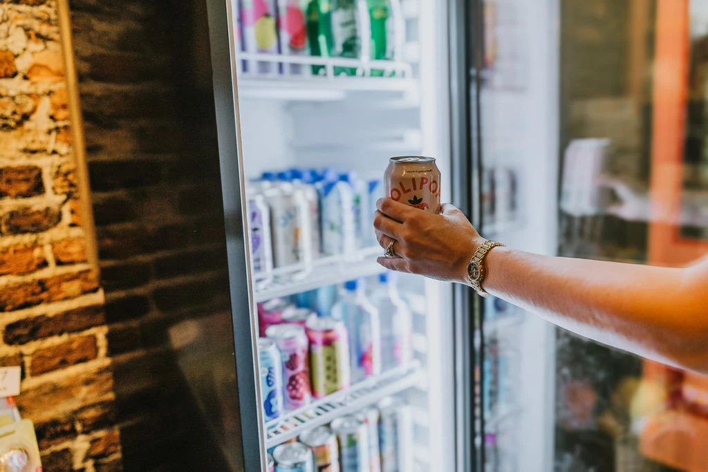 Choosing a drink from the Corals Closet cooler